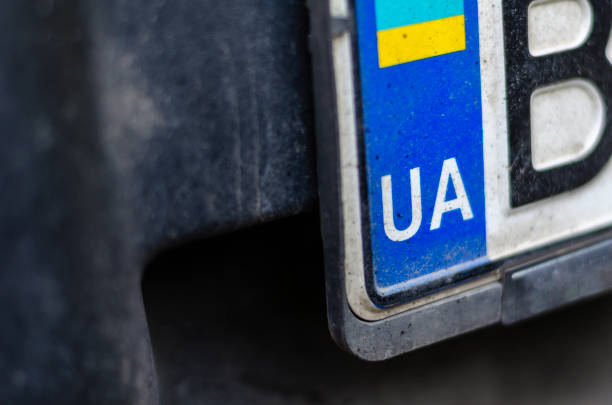 Dirty Ukrainian car license plate with UA in durable license plate frames.