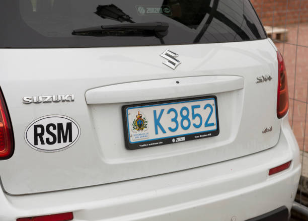 White Suzuki car featuring San Marino license plate frames and an RSM country sticker.