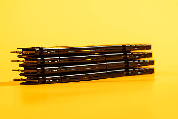 Stacked sleek black license plate frames on a vibrant yellow background.